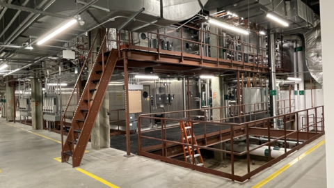 brightly lit mechanical room with pipes and ducts