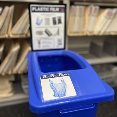 A recycling bin with plastic film signage