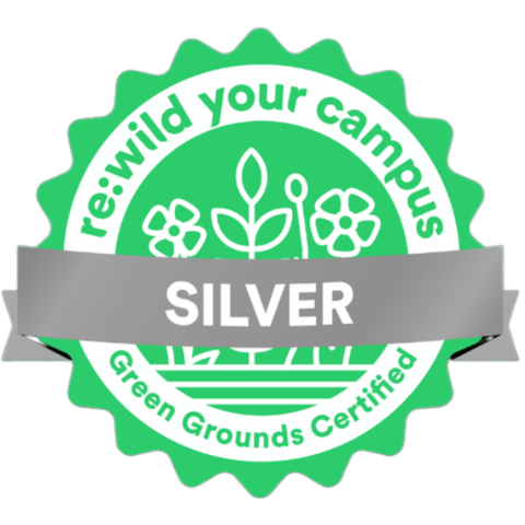green award medallion with a silver band noting green grounds certification