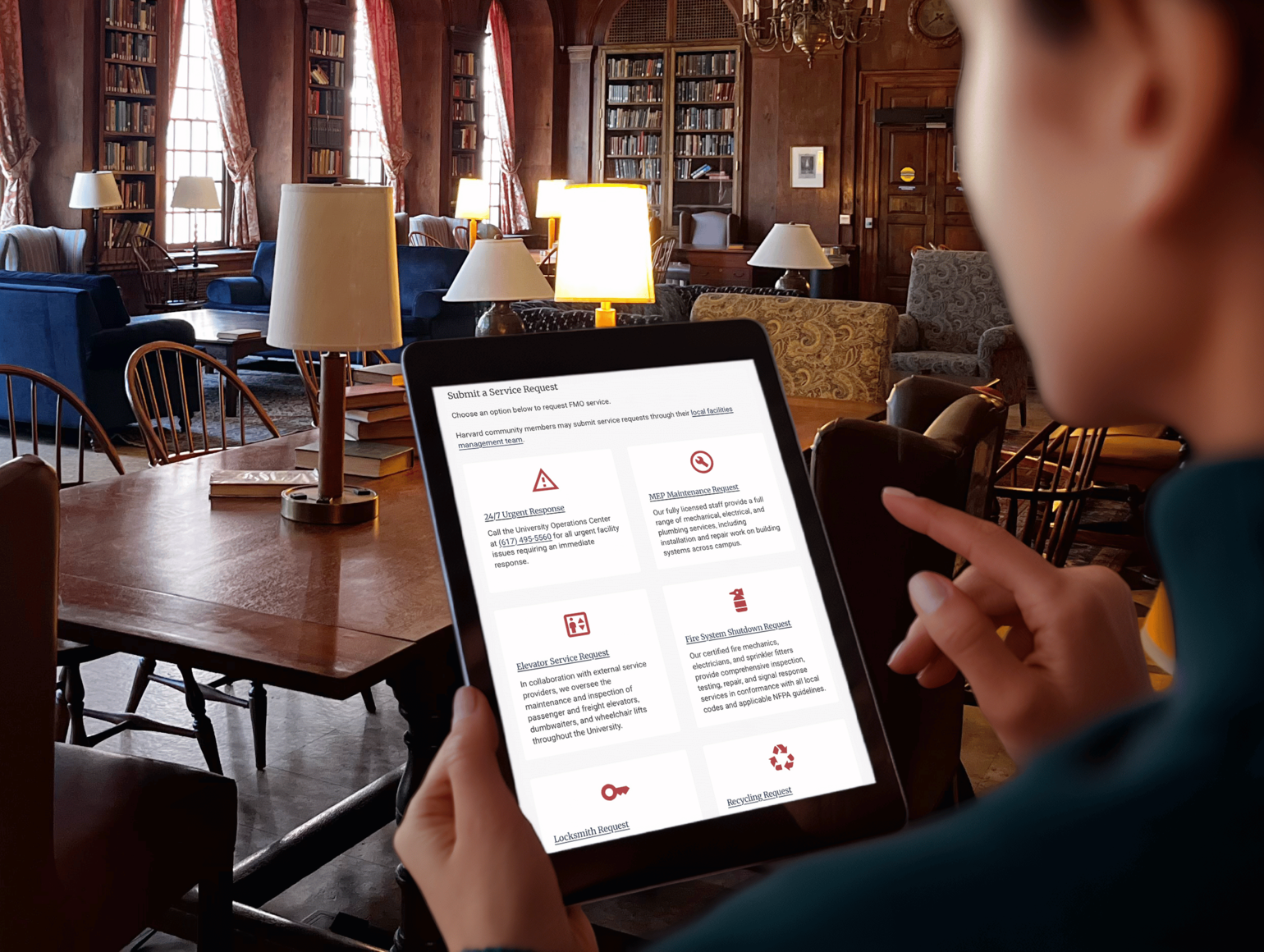 woman uses tablet displaying modern interface in historic Harvard library