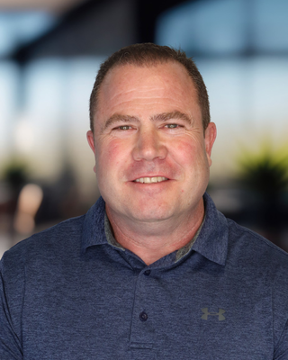 Headshot of a man in a blue polo