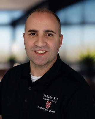 Headshot of a man in a dark polo shirt