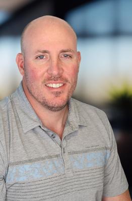 Headshot of a man in a gray striped polo
