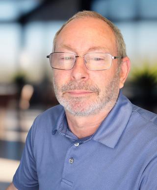 Headshot of a man wearing a blue polo