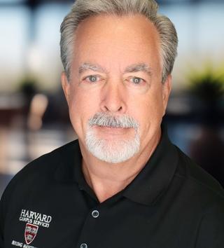 Headshot of a man in a dark polo shirt