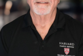 Headshot of a man in a dark polo shirt