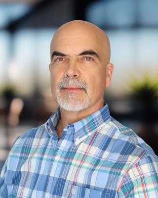 Headshot of a man in a plaid shirt