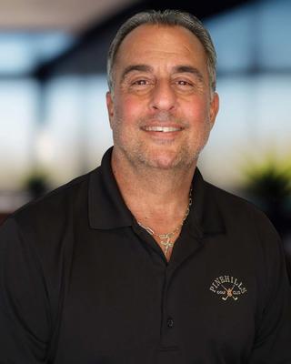 Headshot of a man wearing a black polo