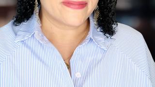 Headshot of a woman in a blue and white shirt
