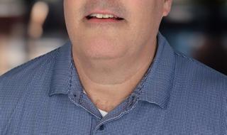 Headshot of a man in a blue polo
