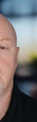 Headshot of a man in a dark polo shirt