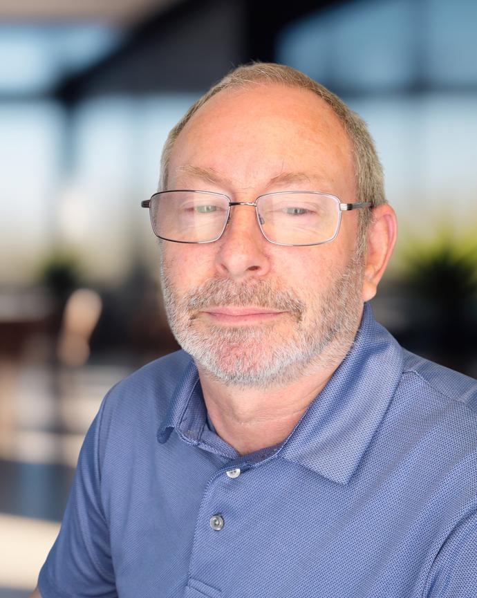 Headshot of a man wearing a blue polo