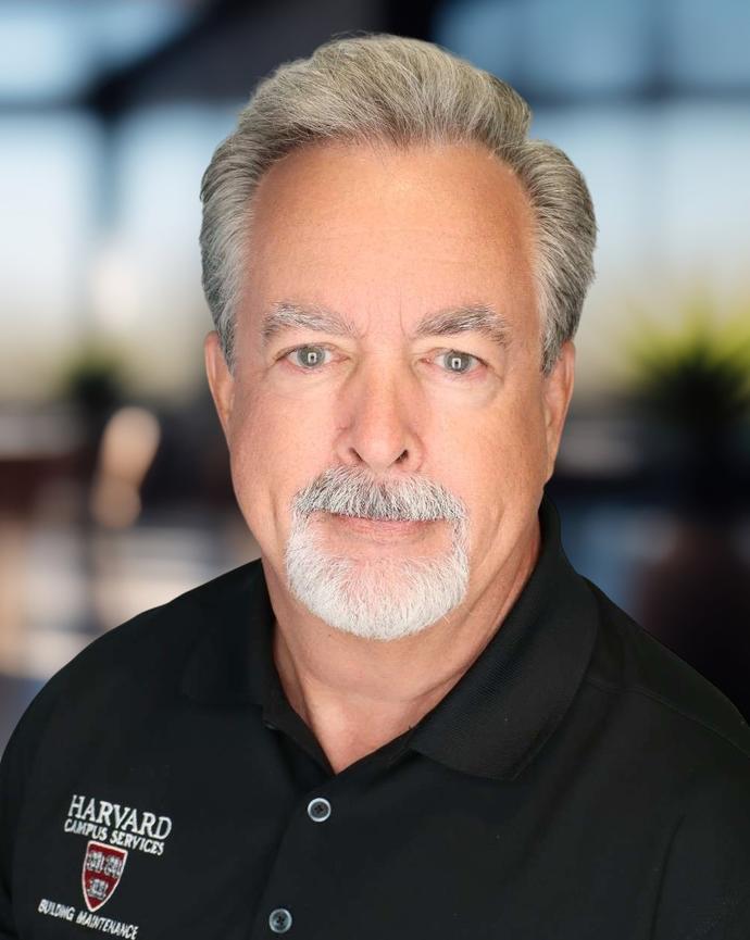 Headshot of a man in a dark polo shirt