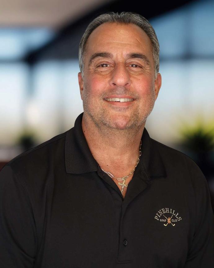 Headshot of a man wearing a black polo