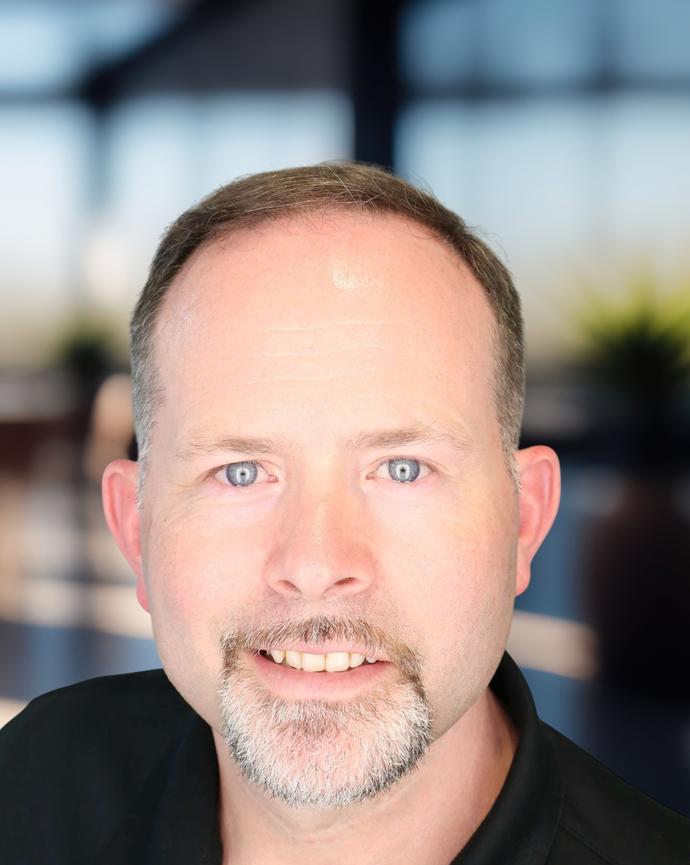 Headshot of a man in a dark polo